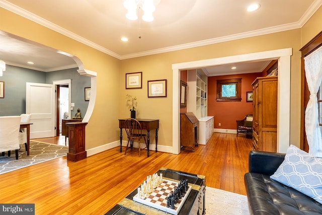 living room featuring ornamental molding, baseboards, arched walkways, and hardwood / wood-style flooring
