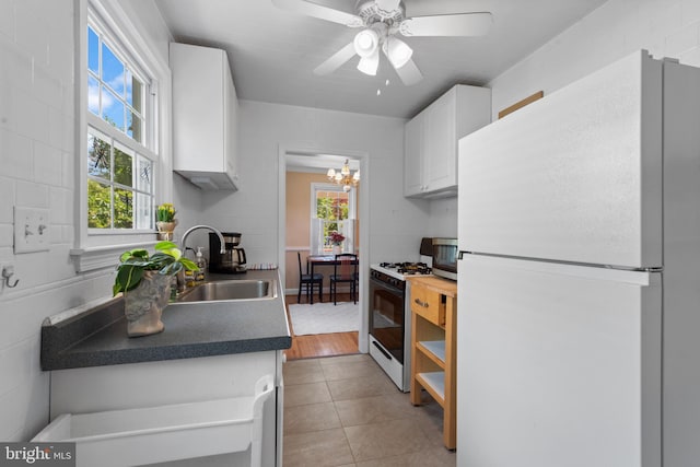 412 Linda Ave, Linthicum Heights, MD 21090 - kitchen featuring freestanding refrigerator, gas range, a sink, white cabinets, and plenty of natural light