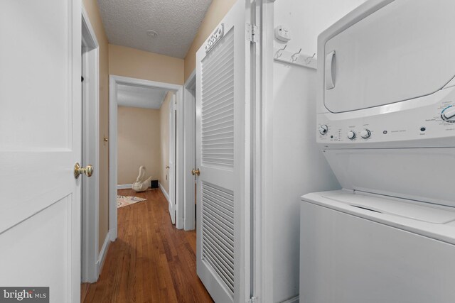 412 Linda Ave, Linthicum Heights, MD 21090 - laundry area with stacked washer / drying machine, wood finished floors, a textured ceiling, and baseboards