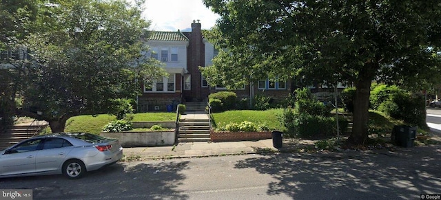 view of front of property with stairs and a chimney