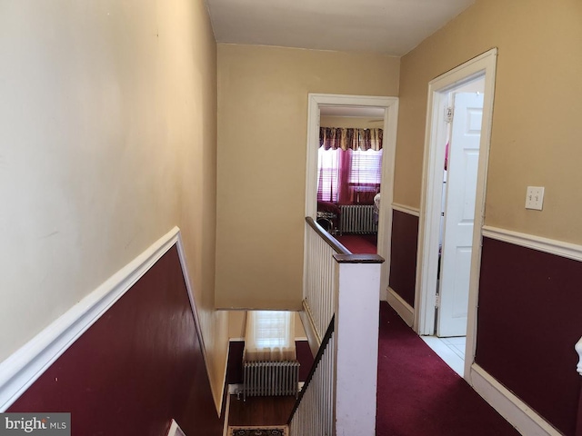 hallway with an upstairs landing and carpet