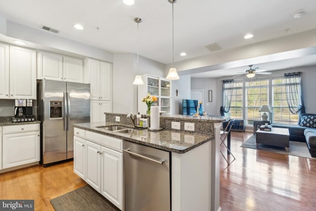 kitchen with ceiling fan, visible vents, appliances with stainless steel finishes, open floor plan, and light wood-style floors