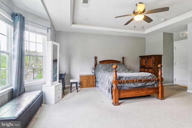 carpeted bedroom with baseboards, a tray ceiling, and visible vents