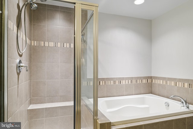 bathroom with a stall shower and a bath