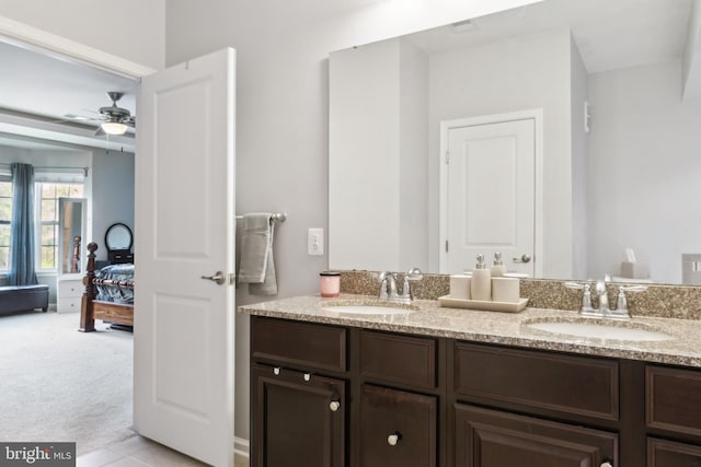 bathroom with double vanity, a sink, ceiling fan, and ensuite bath
