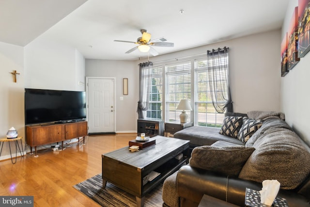 living room with baseboards, light wood finished floors, and ceiling fan