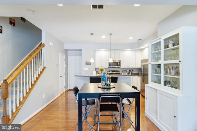 dining area with recessed lighting, light wood-type flooring, stairs, and visible vents