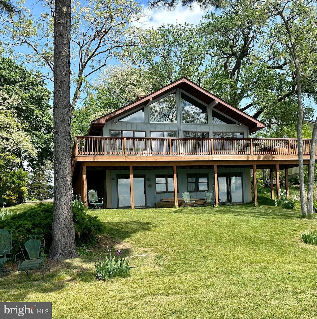 back of property with a lawn and a wooden deck