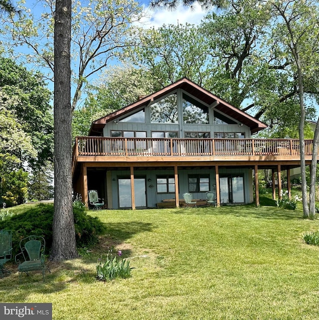 back of property with a lawn and a wooden deck