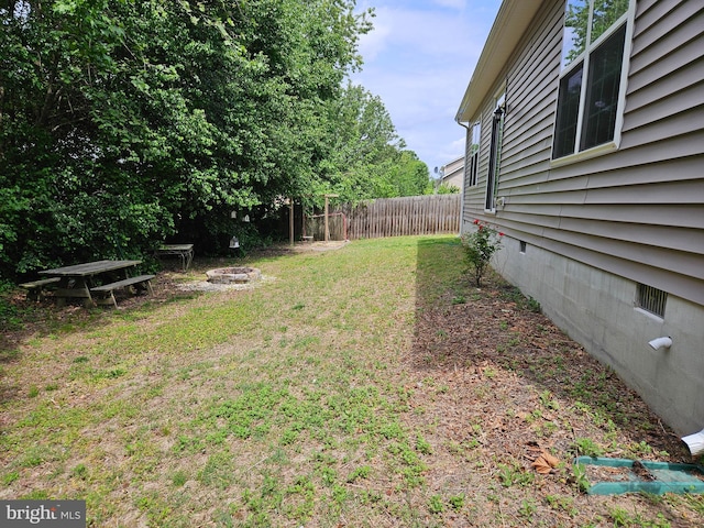 view of yard featuring an outdoor fire pit and fence