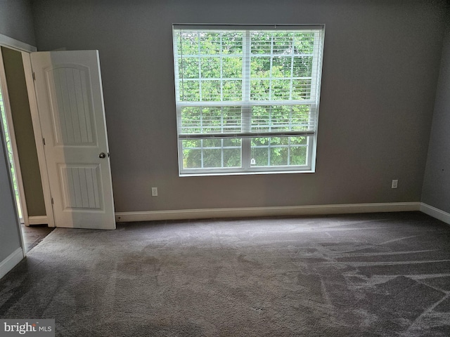 carpeted empty room with baseboards