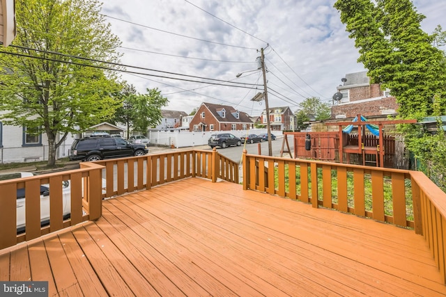 deck with fence, a residential view, and a playground
