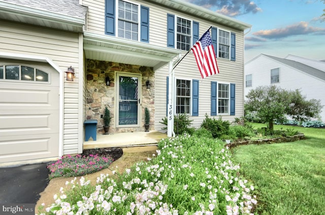 365 Apple Tree Ln, Mount Wolf, PA 17347 - doorway to property with stone siding, a yard, an attached garage, and covered porch