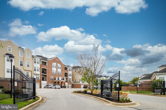 8603 Wintergreen Ct Unit 201, Odenton, MD 21113 - view of asphalt street featuring curbs, street lights, a gated entry, a gate, and a residential view