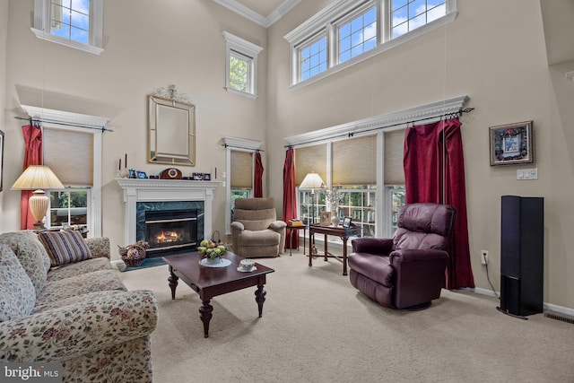 carpeted living room featuring a premium fireplace, crown molding, and a high ceiling