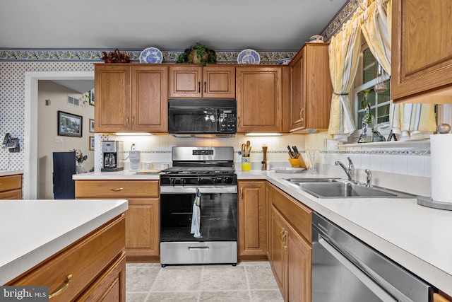 kitchen with a sink, brown cabinetry, stainless steel appliances, and light countertops