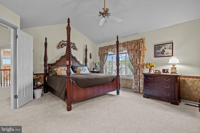 bedroom featuring light colored carpet, lofted ceiling, baseboards, and a ceiling fan