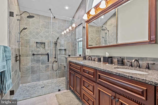 bathroom featuring a sink, double vanity, a stall shower, and tile patterned flooring