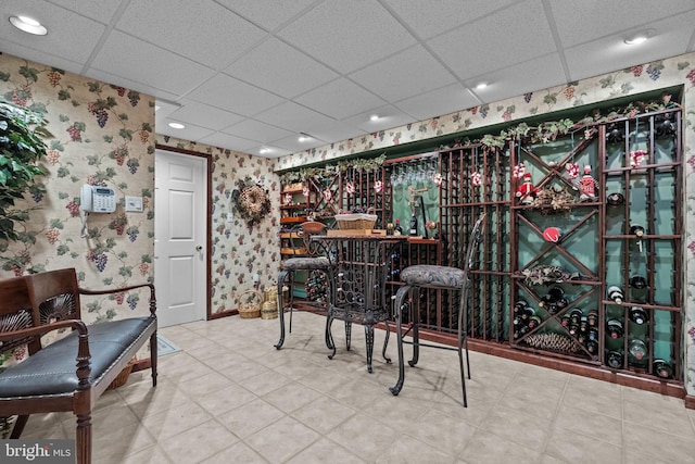 wine cellar featuring recessed lighting, wallpapered walls, and a drop ceiling