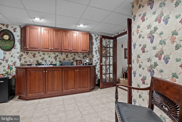 bar featuring a paneled ceiling, recessed lighting, wallpapered walls, and a sink