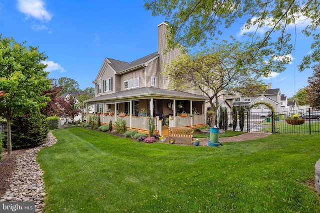 rear view of house featuring a yard, a chimney, and fence