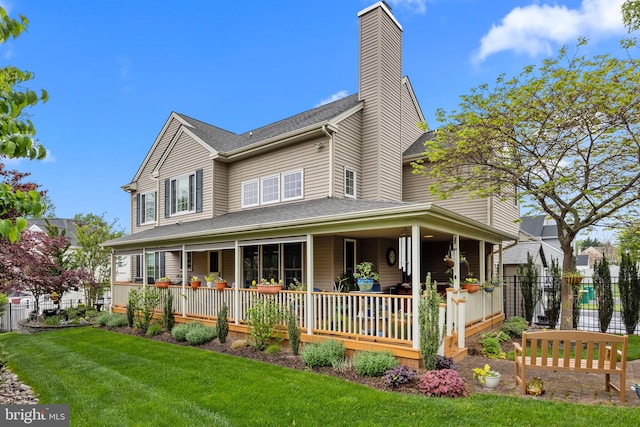 country-style home featuring a front lawn, a chimney, and fence