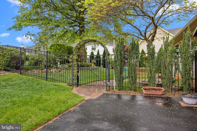 view of gate with a yard and fence