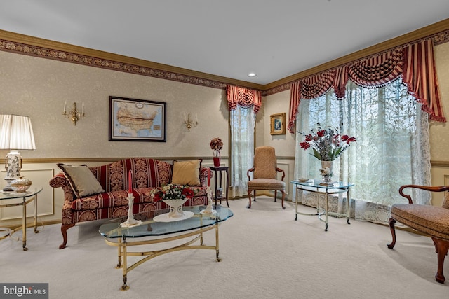 carpeted living area with wainscoting, crown molding, and a decorative wall