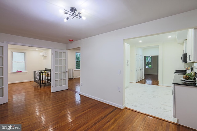 3614 Keene Ave, Baltimore, MD 21214 - empty room featuring radiator heating unit, wood-type flooring, healthy amount of natural light, and recessed lighting