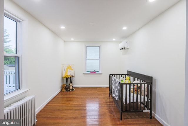 3614 Keene Ave, Baltimore, MD 21214 - bedroom featuring radiator, wood finished floors, a wall mounted air conditioner, recessed lighting, and baseboards