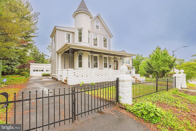 3614 Keene Ave, Baltimore, MD 21214 - victorian house featuring a porch, a fenced front yard, a garage, and an outbuilding