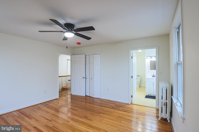 3614 Keene Ave, Baltimore, MD 21214 - unfurnished bedroom featuring radiator heating unit, light wood-style flooring, baseboards, connected bathroom, and a closet