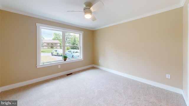 empty room with baseboards, light carpet, ornamental molding, and a ceiling fan