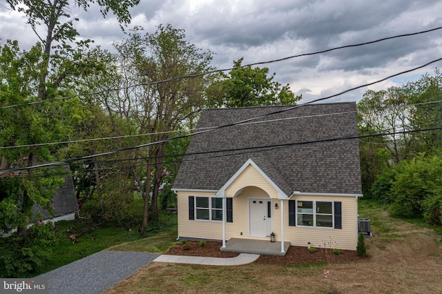 view of front of home with a shingled roof and cooling unit