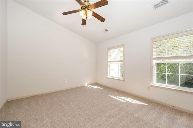 carpeted empty room featuring vaulted ceiling, a ceiling fan, and baseboards