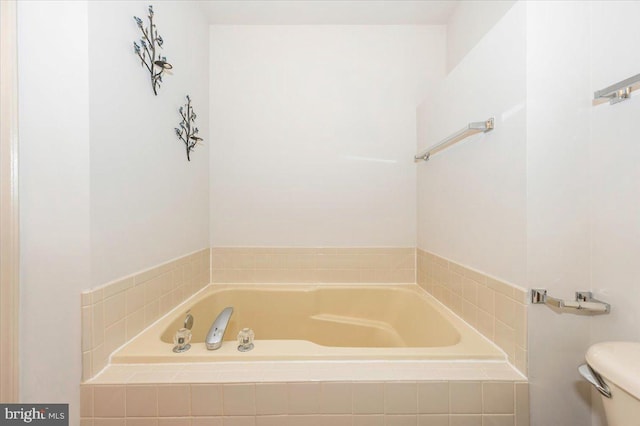full bathroom featuring a garden tub and toilet