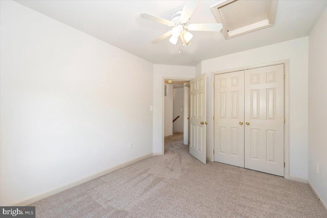 unfurnished bedroom featuring carpet flooring, a closet, baseboards, and attic access