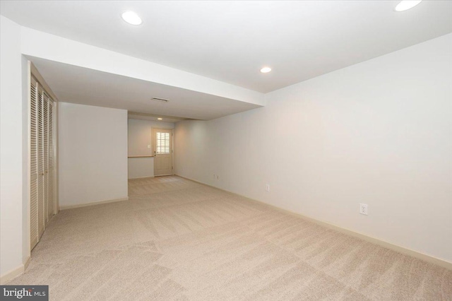 below grade area featuring light colored carpet, recessed lighting, and baseboards