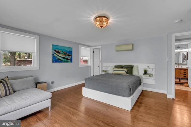 8014 Forest Glen Dr, Pasadena, MD 21122 - bedroom with a wall mounted air conditioner, wood finished floors, and baseboards