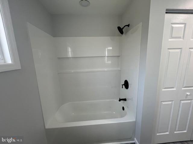 bathroom featuring baseboards and shower / tub combination
