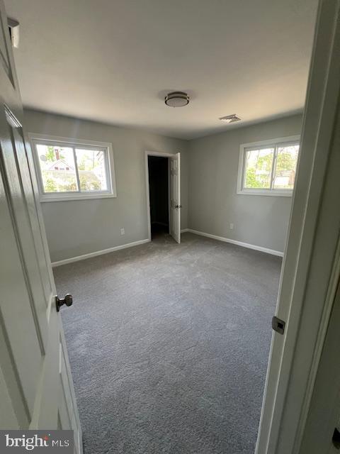 carpeted spare room with baseboards and visible vents