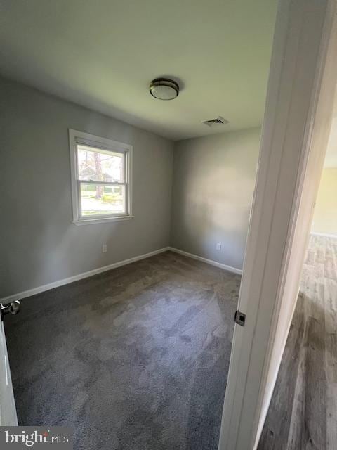 unfurnished room featuring baseboards, carpet floors, and visible vents