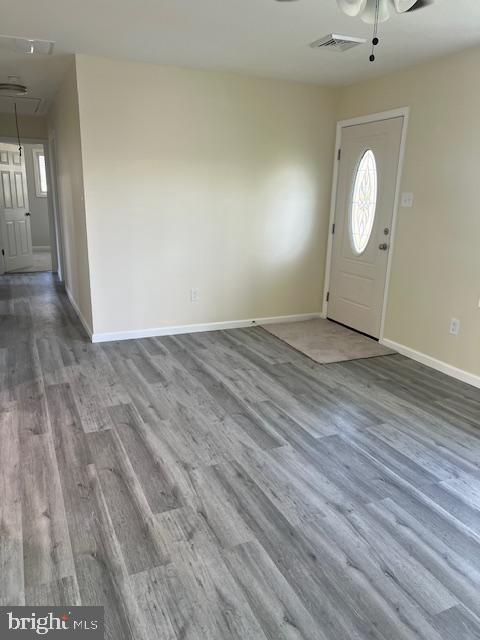 foyer with visible vents, baseboards, ceiling fan, and wood finished floors