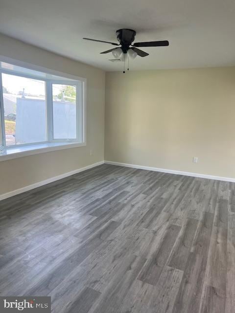 spare room featuring baseboards, a ceiling fan, and wood finished floors