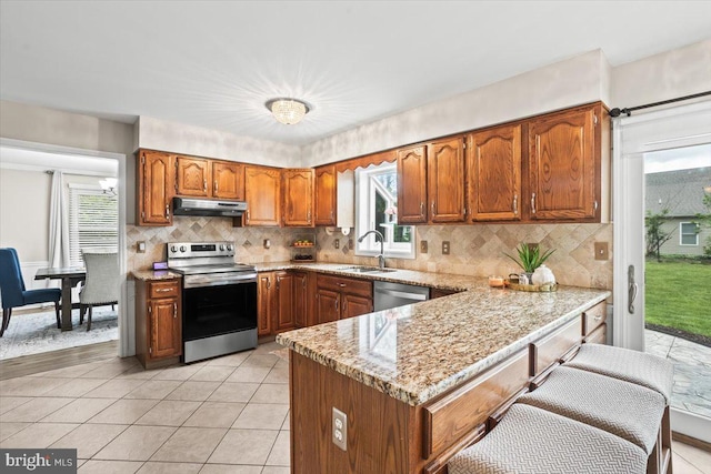 6122 Wallingford Way, Mechanicsburg, PA 17050 - kitchen featuring under cabinet range hood, a sink, a peninsula, brown cabinets, and appliances with stainless steel finishes