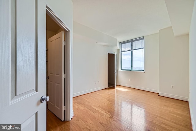 unfurnished room with light wood-style floors and baseboards