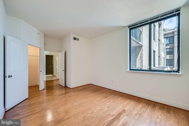 unfurnished bedroom with visible vents, baseboards, and light wood-type flooring