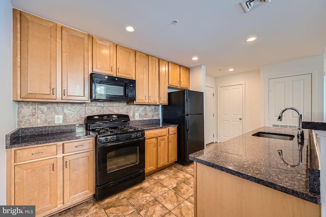 kitchen with a sink, light brown cabinets, backsplash, visible vents, and black appliances