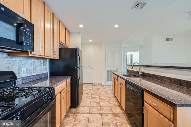 kitchen featuring a sink, decorative backsplash, black appliances, and visible vents