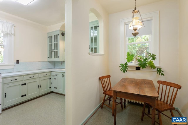dining space featuring arched walkways and a healthy amount of sunlight